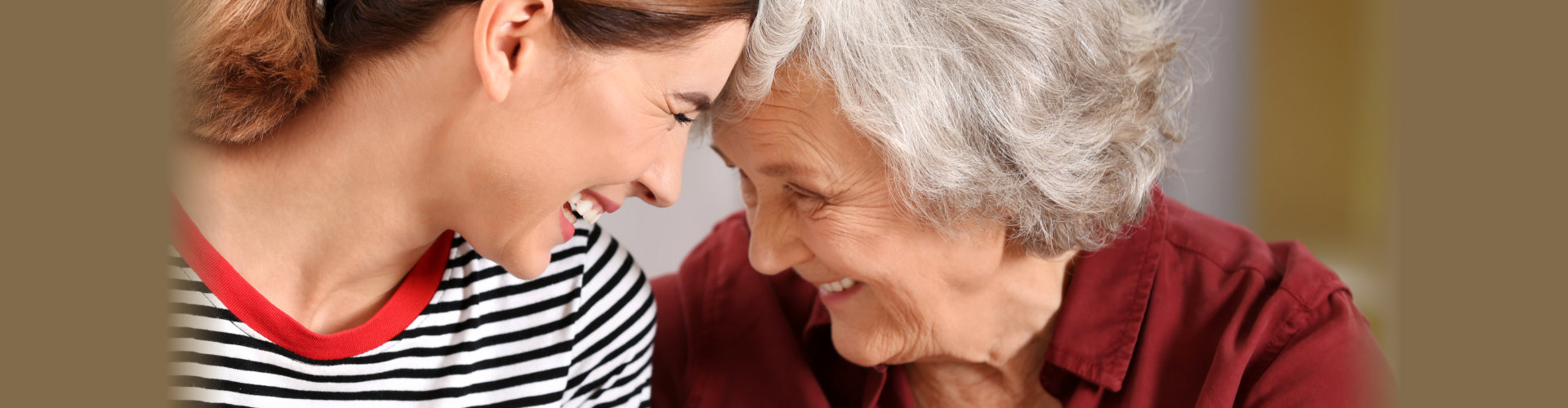 Elderly woman with female caregiver on blurred background